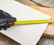 A detail of male hand measuring drywall panel